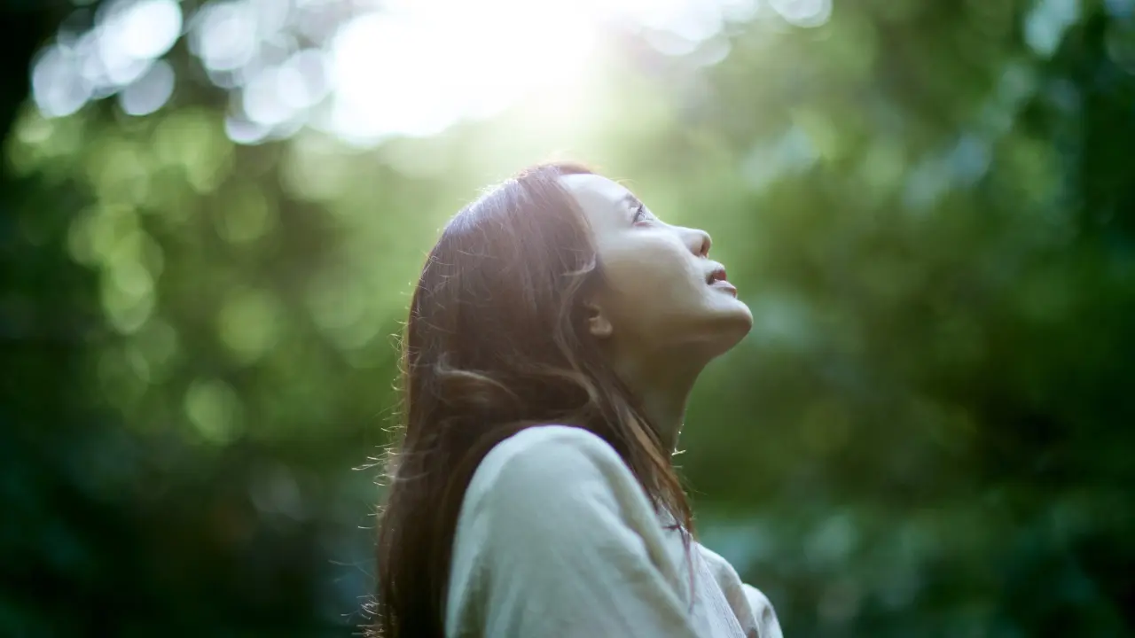 Bien etre mental Photo d'une femme dans la forêt regardant le ciel l'ai apaisée représentant le bien être mental