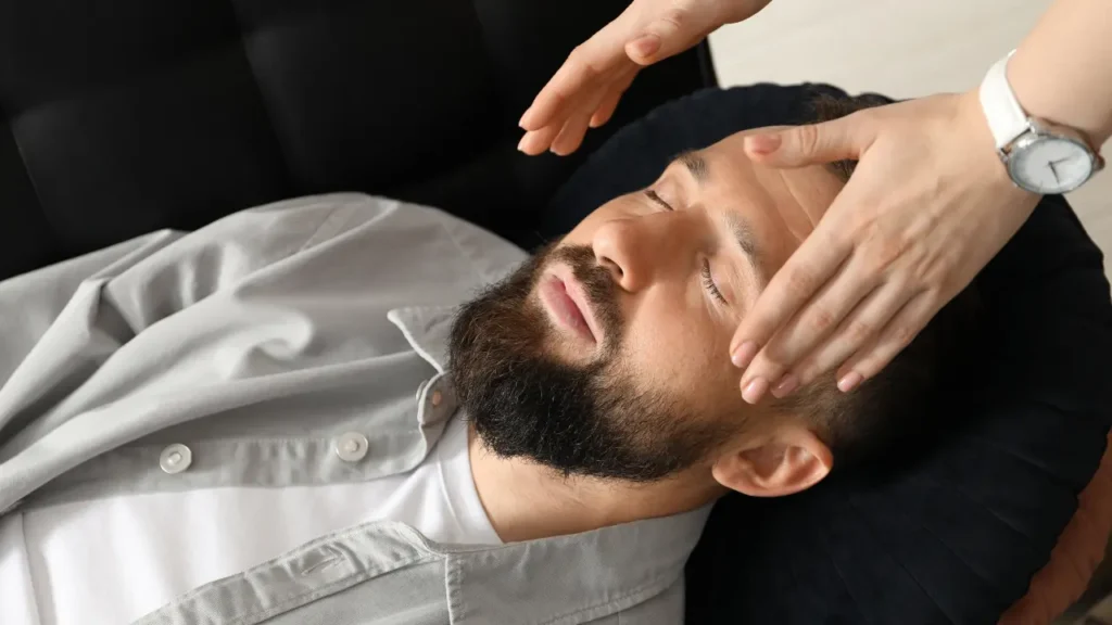 Photo d'un homme allongé sur un canapé qui se fait hypnotiser pour dormir