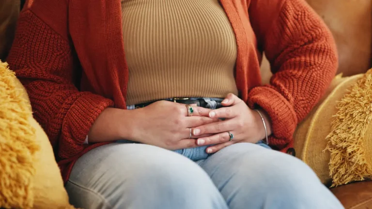 Femme assise sur un canapé souffrant du syndrome de l'intestin irritable