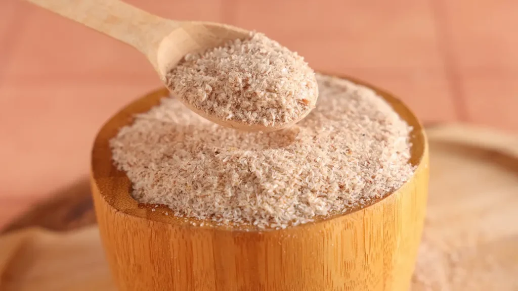 Psyllium en poudre dans un bol avec cuillère en bois, illustrant l’utilisation du psyllium pour soulager la constipation, avec indications de dosage en 2026.